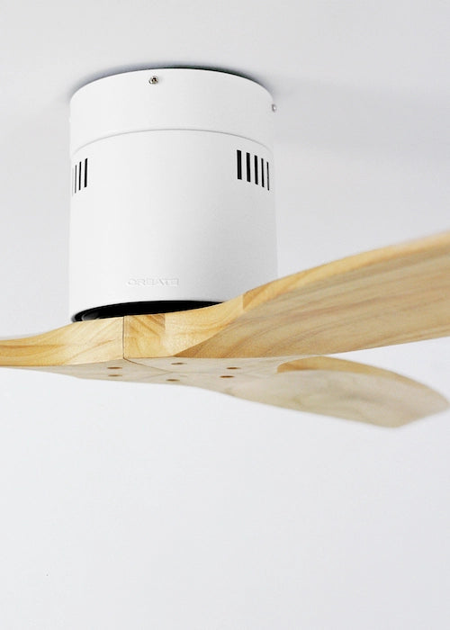 Close-up of CREATE WINDCALM white motor housing and light wood ceiling fan blade